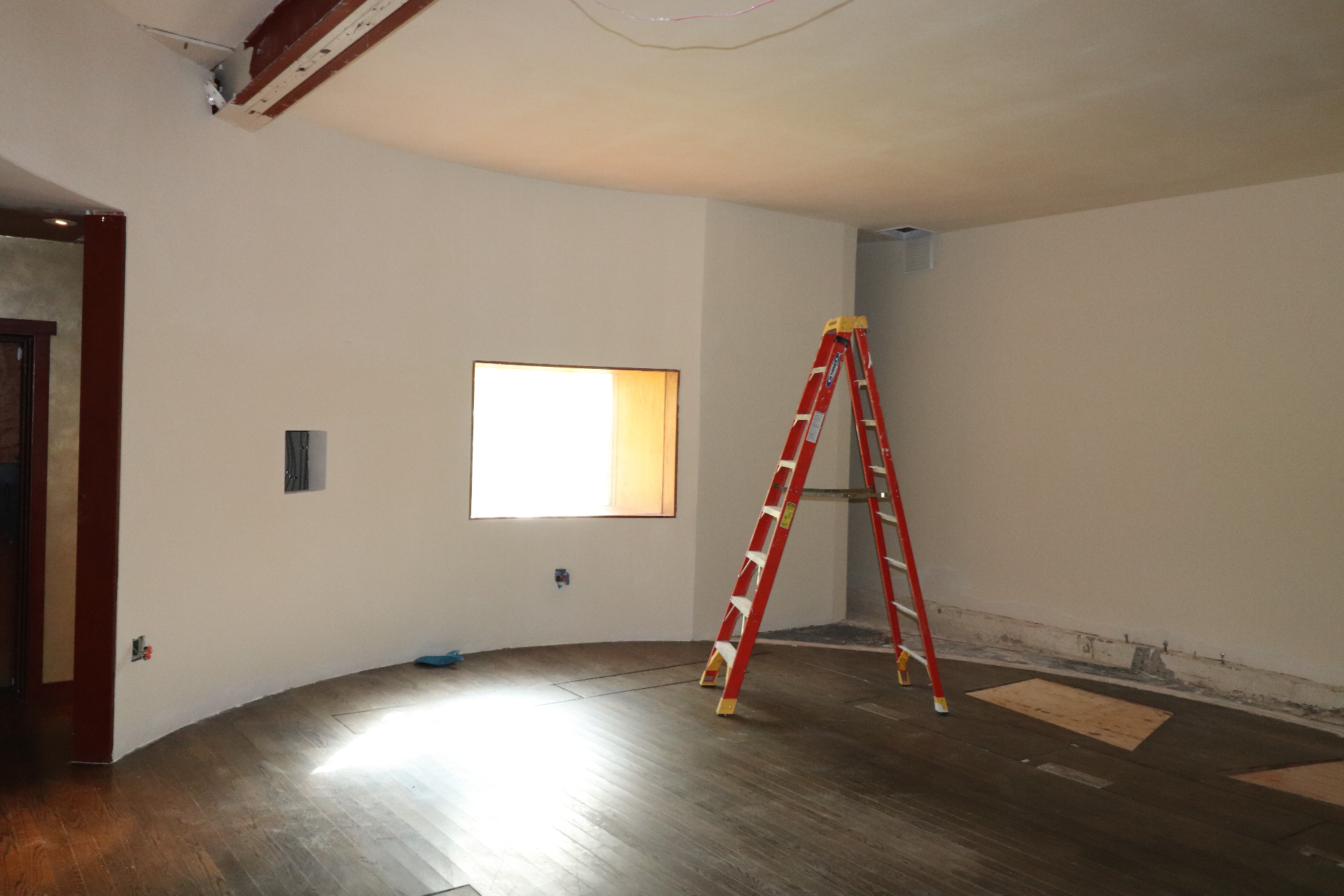 The Garden Studio mid-renovation in March 2026, plywood boards covering floor sections where sub-woofers once sat